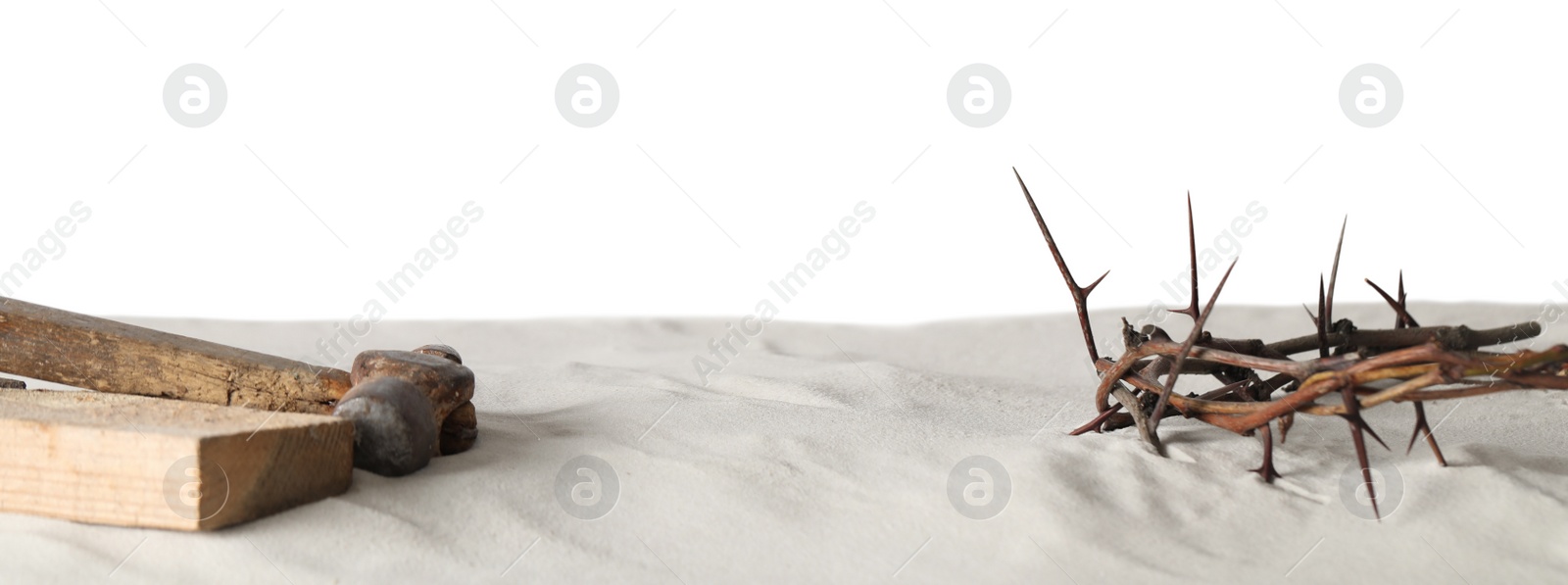 Photo of Crown of thorns, wooden plank and hammer on sand against white background, space for text. Easter attributes