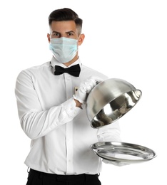 Waiter in medical face mask holding tray with lid on white background