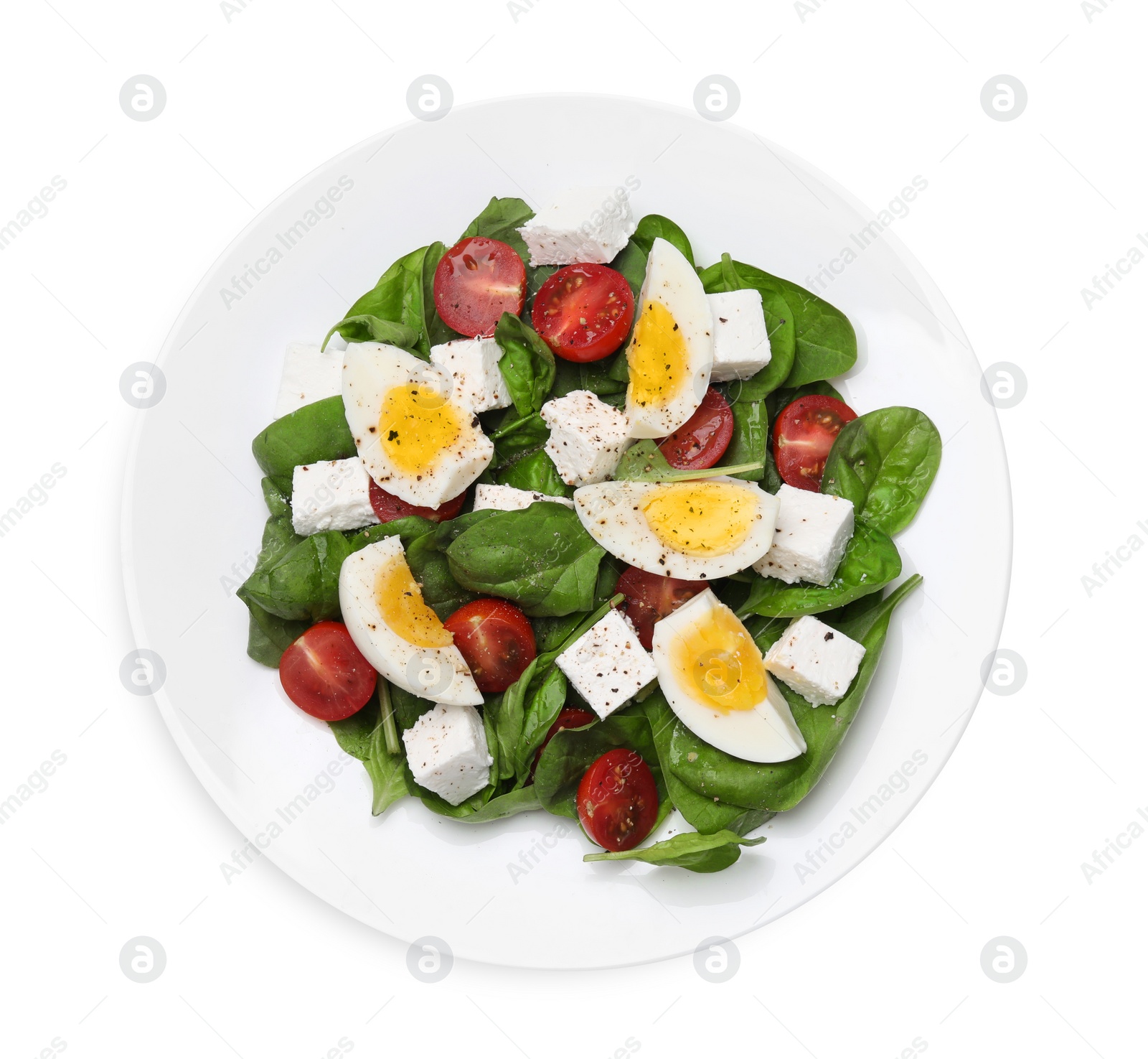 Photo of Delicious salad with boiled eggs, feta cheese and tomatoes isolated on white, top view