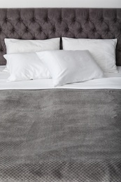 Photo of Soft white pillows on comfortable bed, closeup