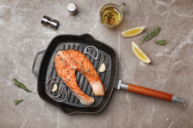 Frying pan with fresh raw salmon steak on table, top view