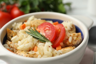 Photo of Delicious chicken risotto served in bowl, closeup