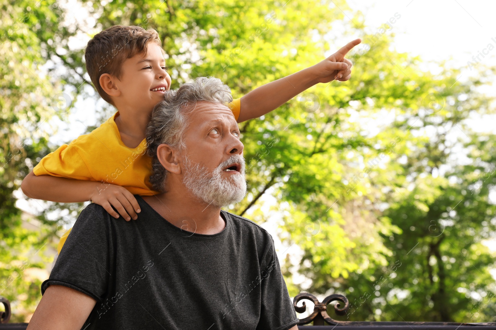 Photo of Senior man with his little grandson in park