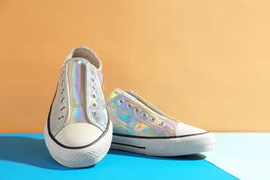 Photo of Pair of stylish sneakers on table against color background