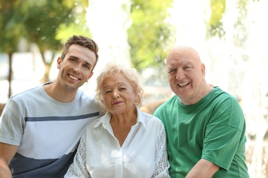 Photo of Man with elderly parents outdoors on sunny day