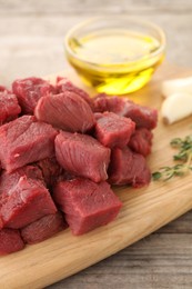 Photo of Pieces of raw beef meat on wooden table, closeup