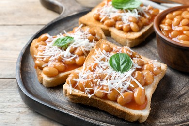 Photo of Toasts with delicious canned beans on wooden table, closeup