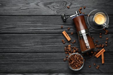 Manual coffee grinder with powder and beans on wooden table, flat lay. Space for text