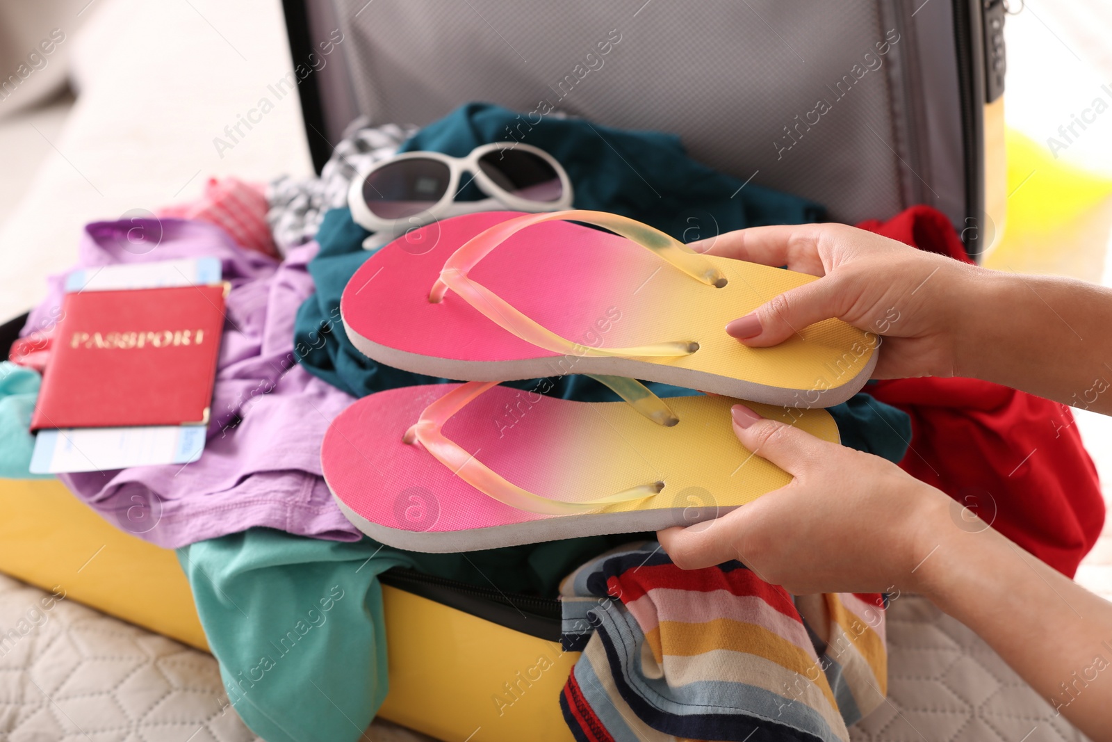 Photo of Woman packing suitcase for journey at home, closeup