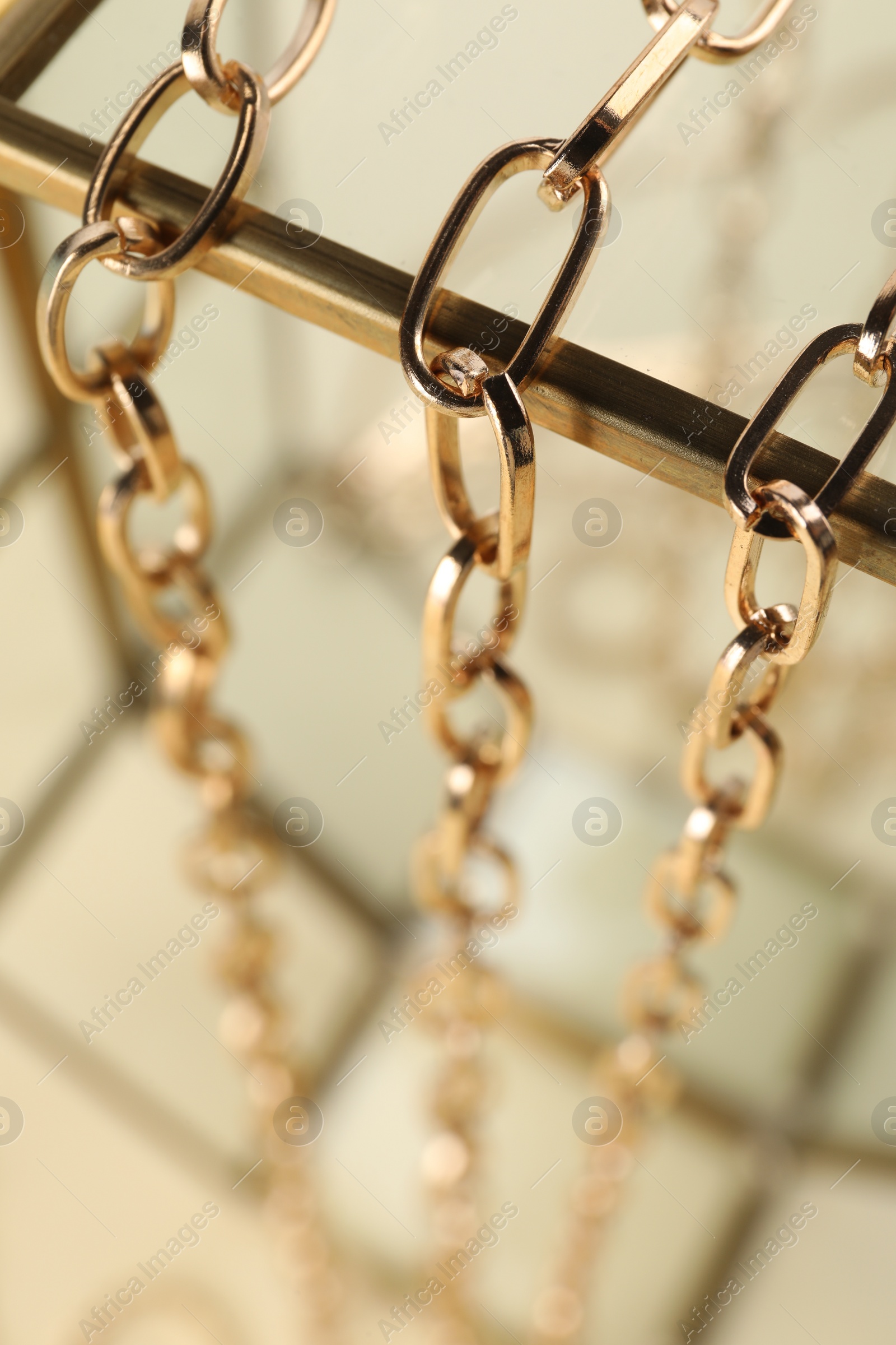 Photo of Stand with different metal chains, closeup. Luxury jewelry