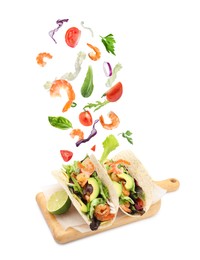 Image of Delicious tacos. Ingredients falling into tortillas on white background