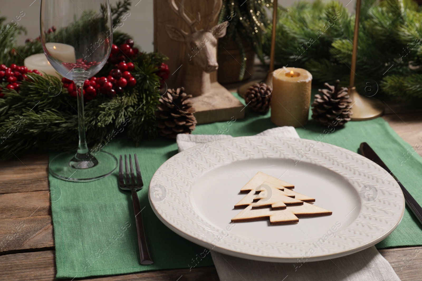 Photo of Festive place setting with beautiful dishware, cutlery and decor for Christmas dinner on wooden table