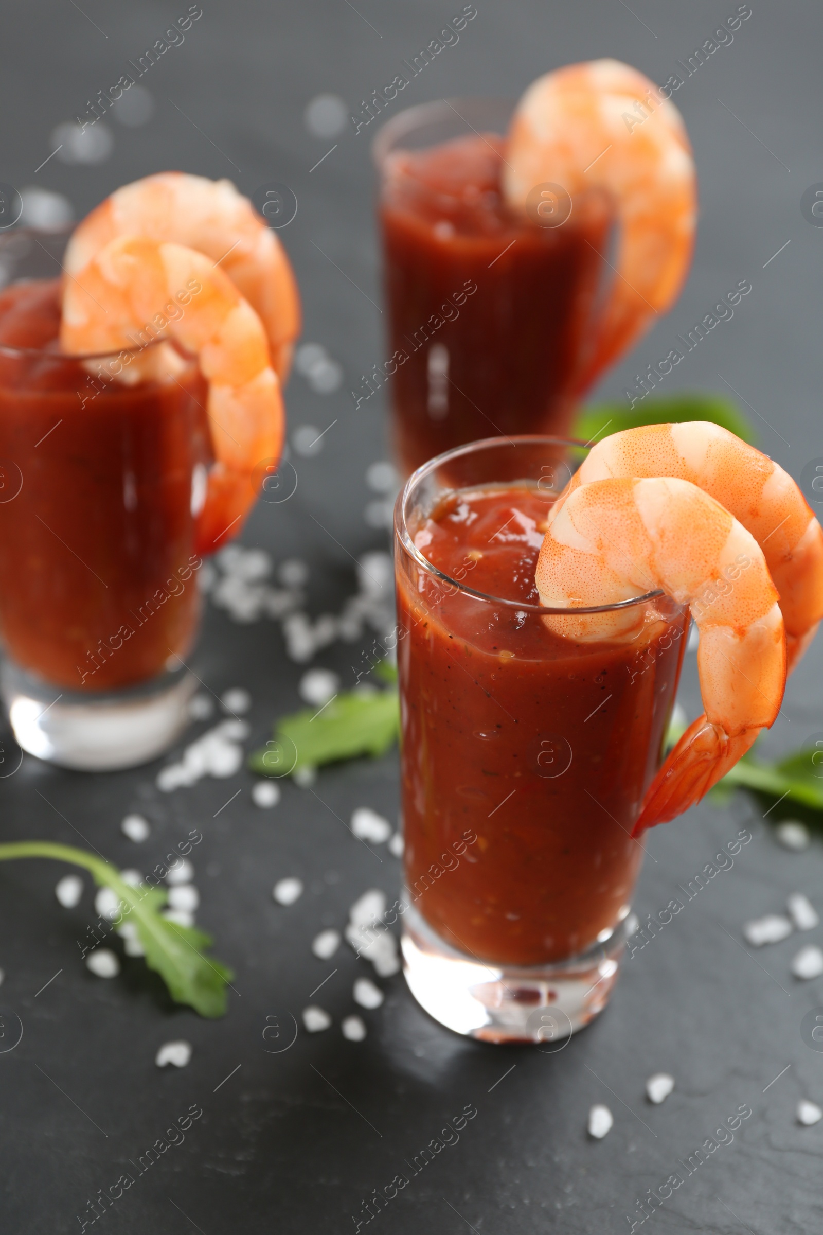 Photo of Delicious shrimp cocktail with tomato sauce served on black table