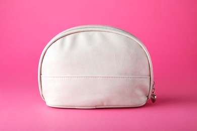 White leather cosmetic bag on pink background