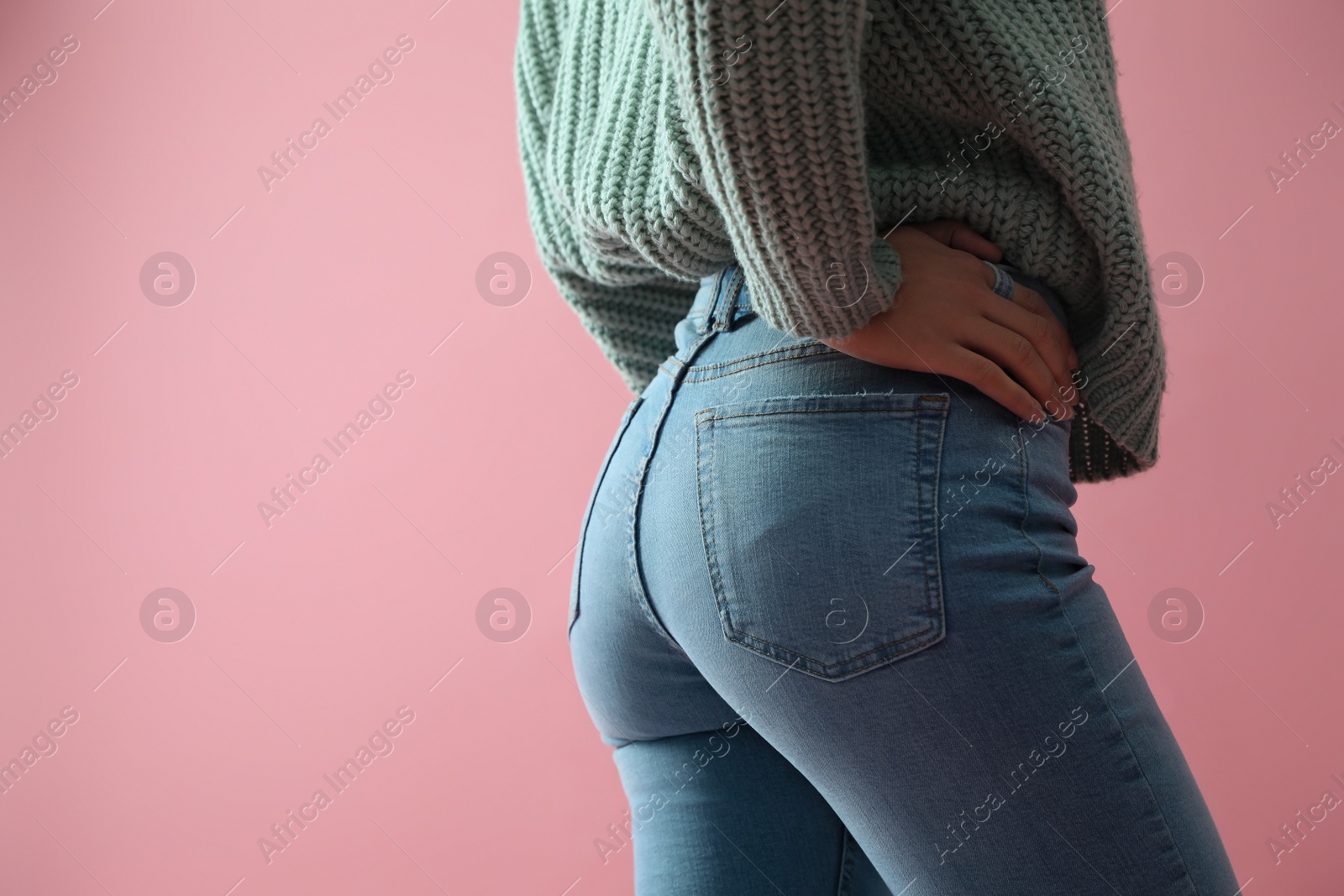 Photo of Woman wearing jeans on pink background, closeup. Space for text