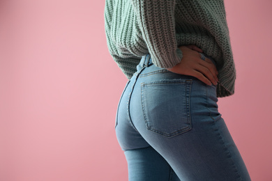 Woman wearing jeans on pink background, closeup. Space for text