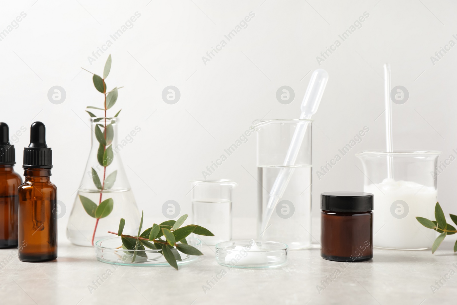 Photo of Natural ingredients for cosmetic products and laboratory glassware on white table