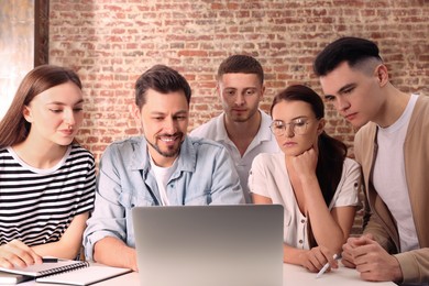 Photo of Team of employees working together in office