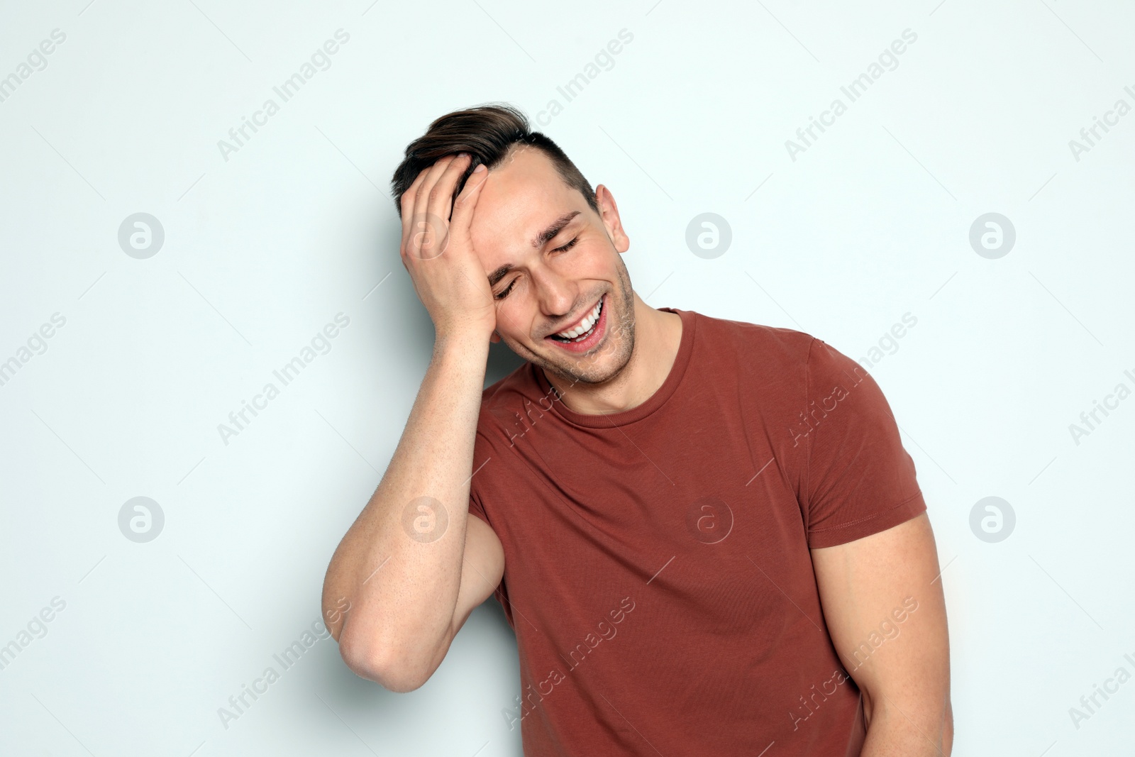 Photo of Portrait of handsome man laughing against light background