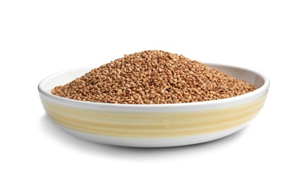 Bowl with uncooked buckwheat on white background