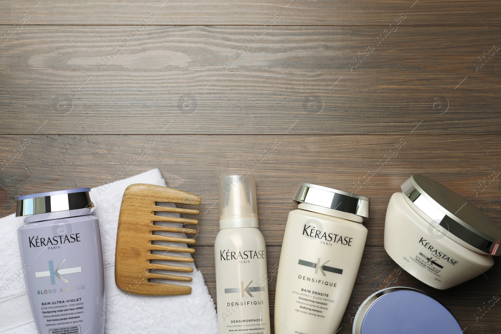 Photo of MYKOLAIV, UKRAINE - SEPTEMBER 07, 2021: Flat lay composition with Kerastase hair care cosmetic products on wooden table. Space for text