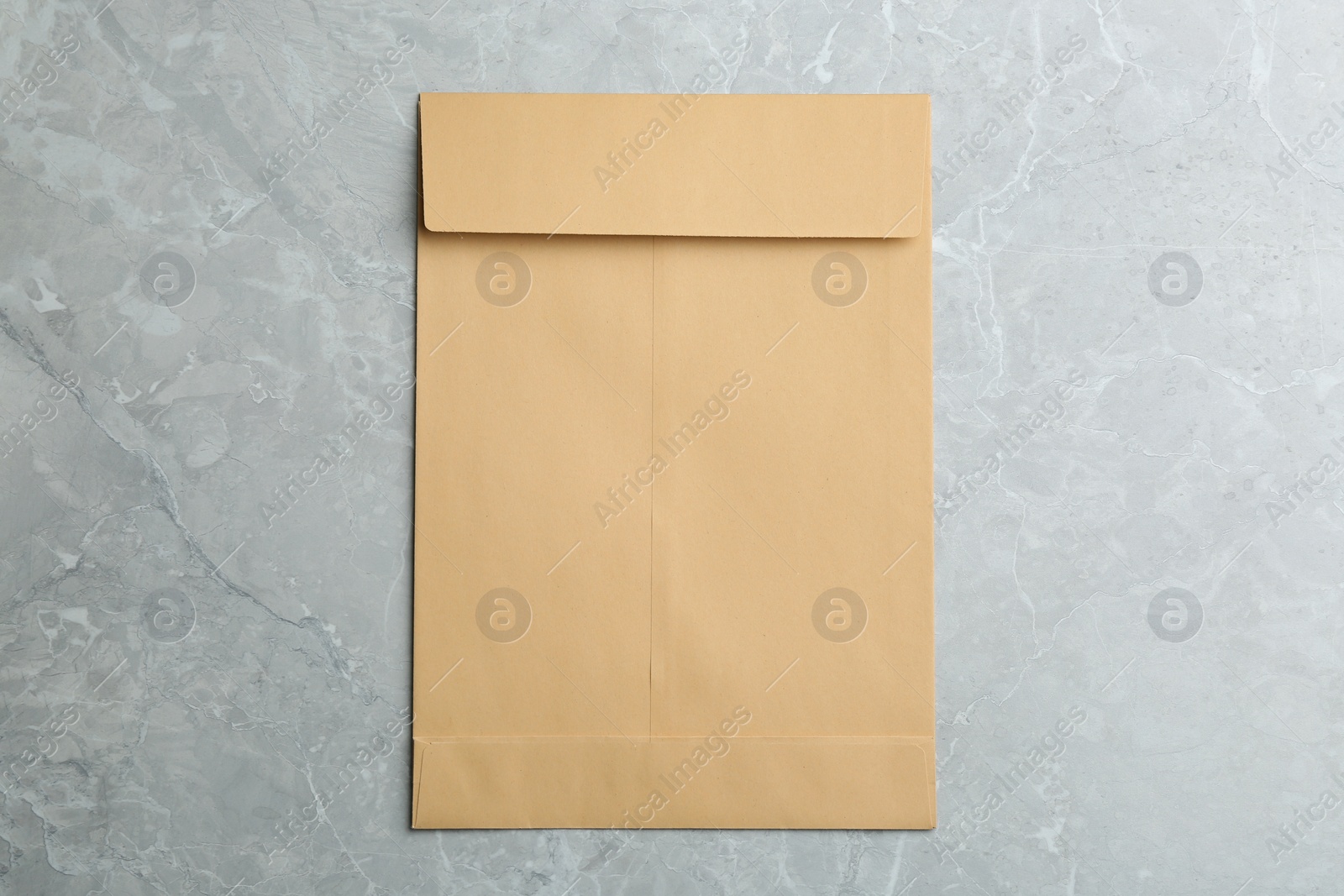 Photo of Kraft paper envelope on grey background, top view