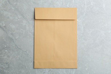 Photo of Kraft paper envelope on grey background, top view