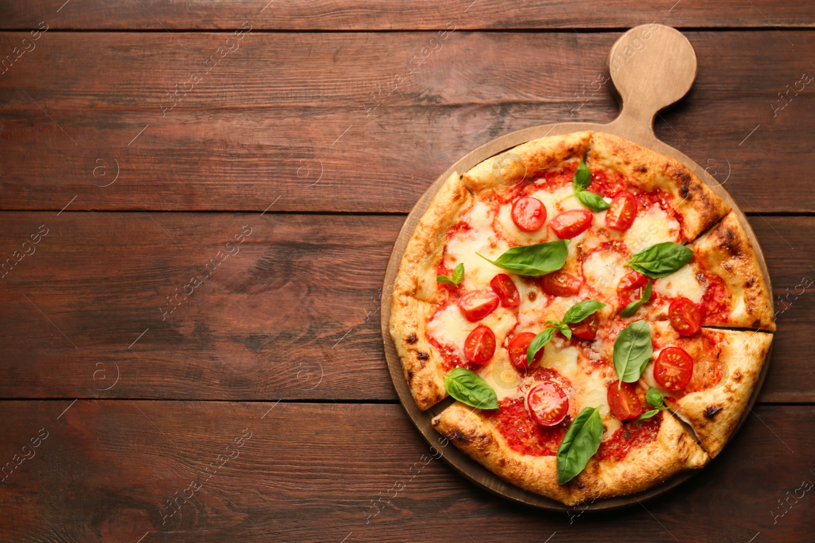 Photo of Delicious Margherita pizza on wooden table, top view. Space for text