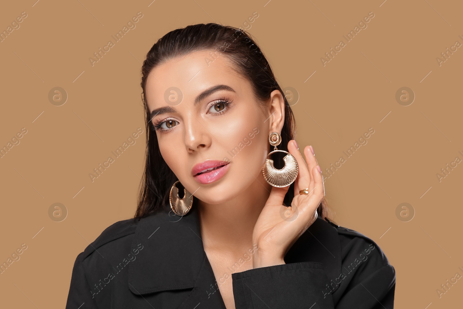 Photo of Portrait of young woman with beautiful makeup on light brown background