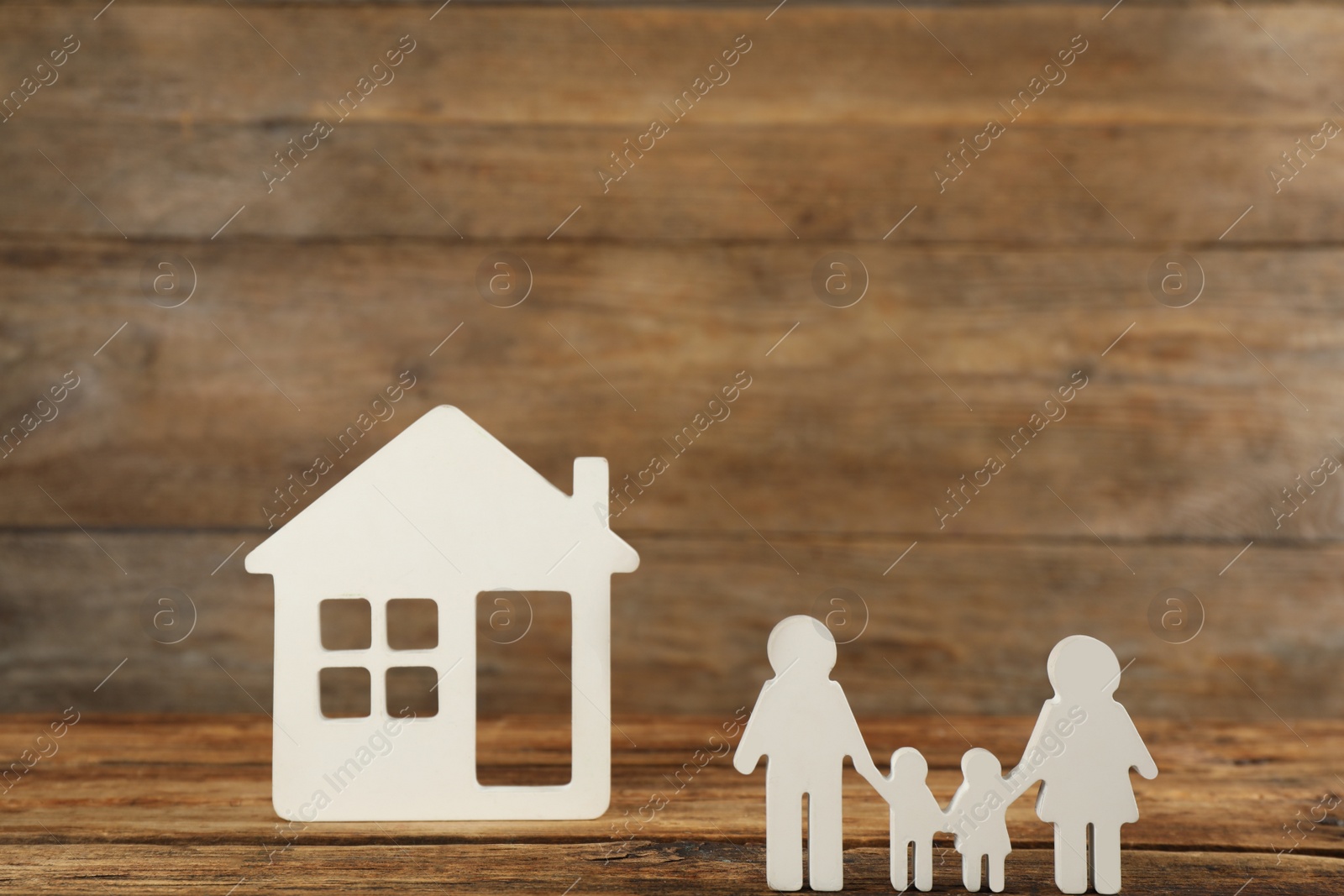 Photo of Family figure and house model on wooden table. Child adoption concept