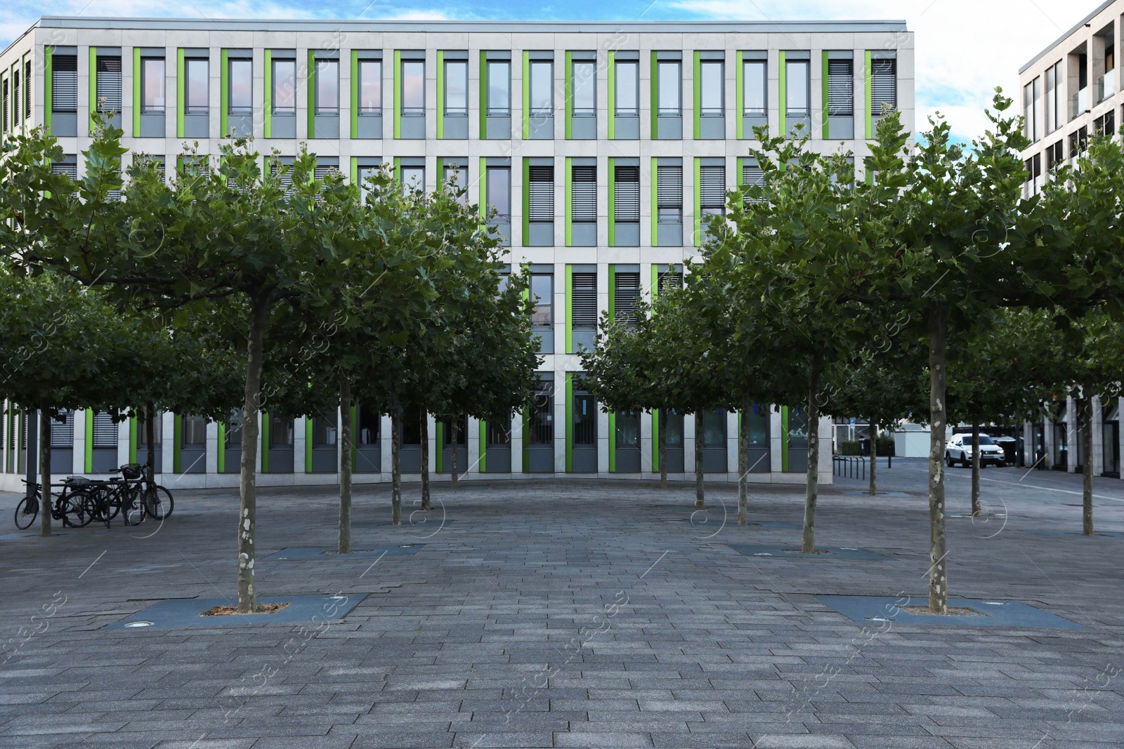 Photo of Beautiful view of modern building with big windows and trees outdoors