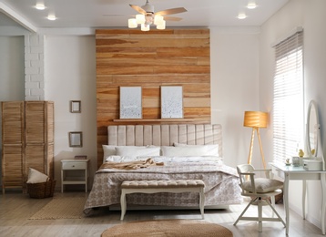 Stylish bedroom interior with modern ceiling fan and comfortable bench