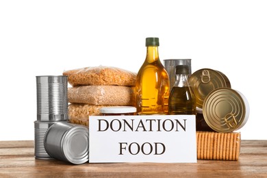Photo of Card with words Donation Food and different products on wooden table against white background