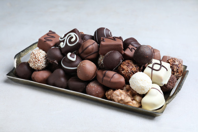 Photo of Different tasty chocolate candies on white table