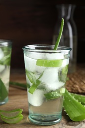 Photo of Fresh aloe drink with ice cubes on wooden table