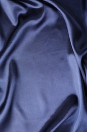 Photo of Crumpled dark blue silk fabric as background, top view