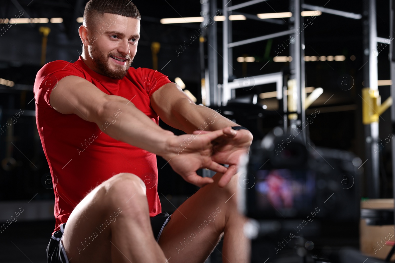 Photo of Man recording workout on camera at gym. Online fitness trainer