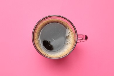 Photo of Fresh coffee in cup on pink background, top view