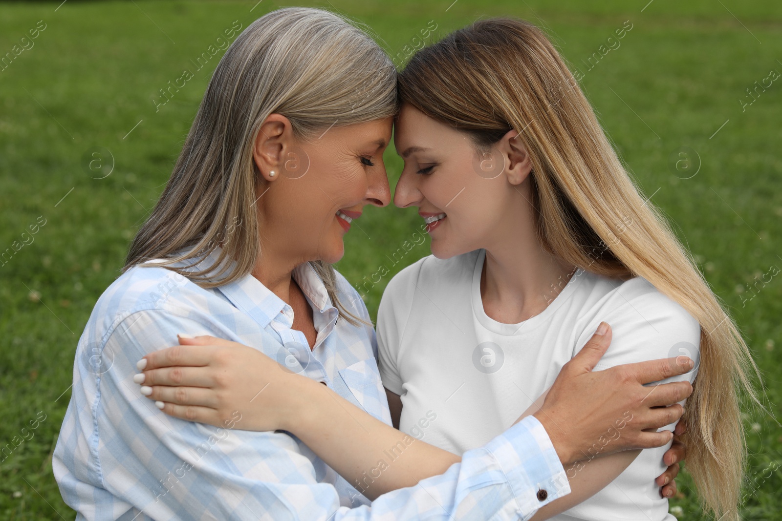 Photo of Happy mature mother and her daughter hugging outdoors