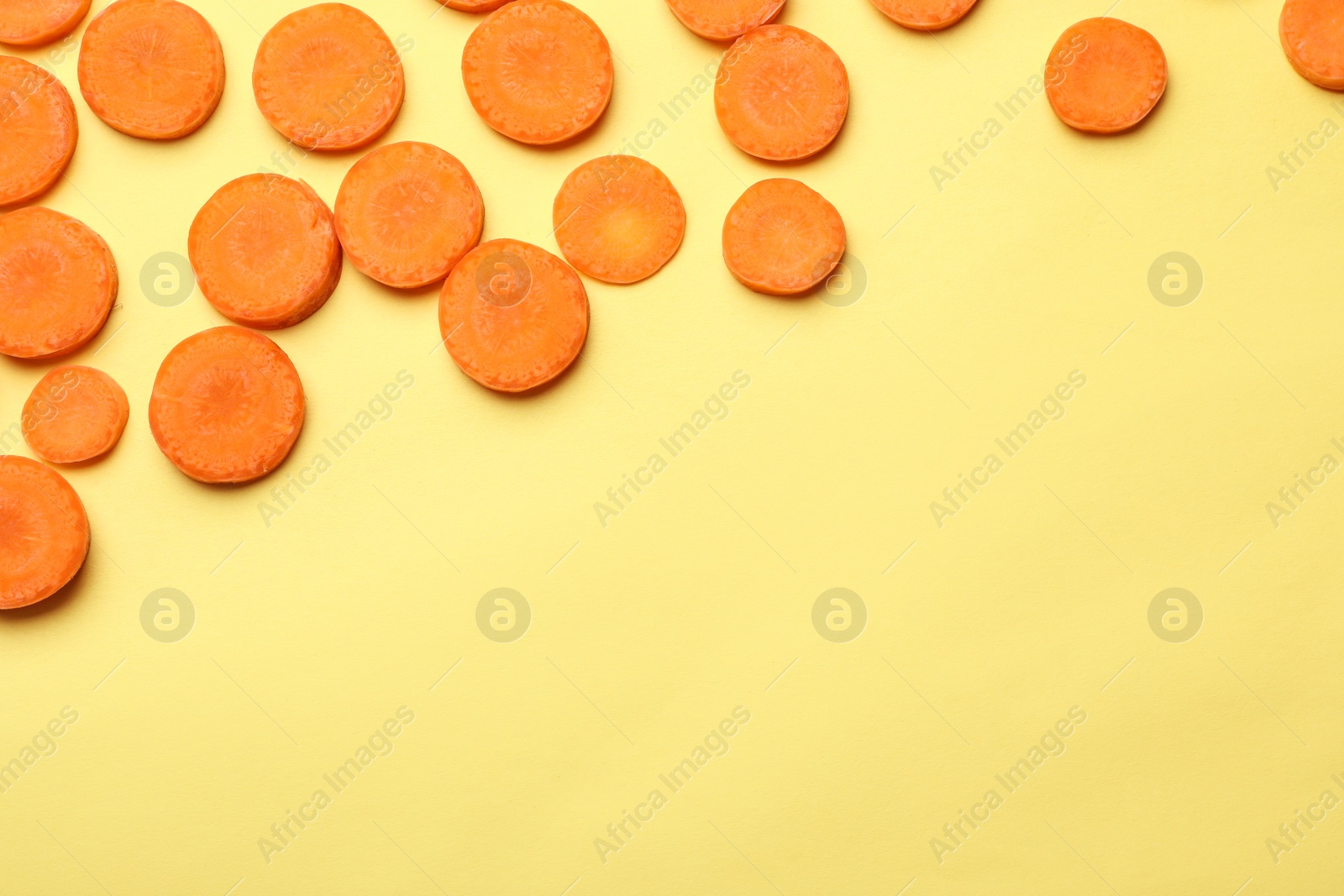 Photo of Flat lay composition with carrot slices on color background. Space for text