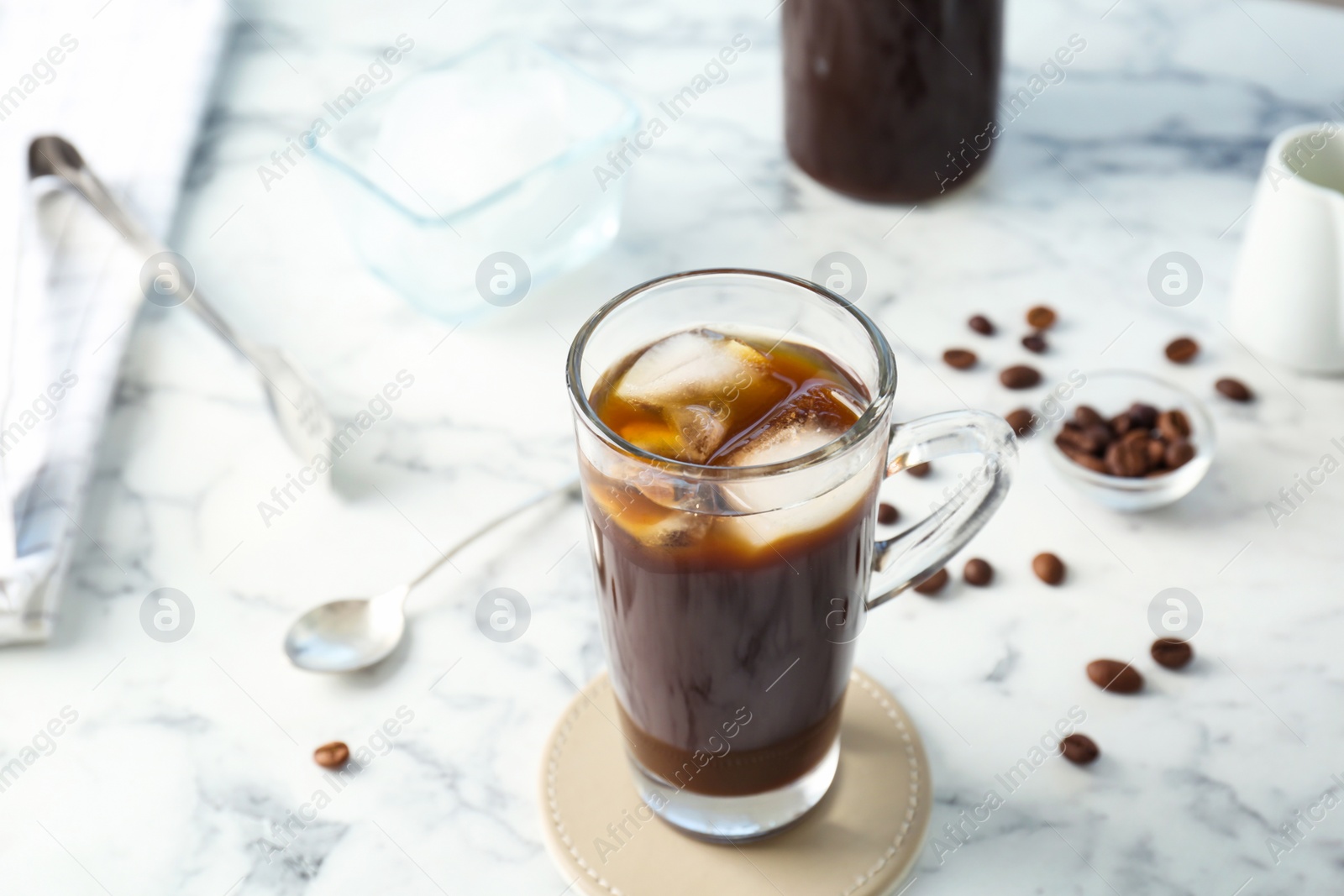 Photo of Glass cup with cold brew coffee on light background