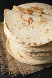 Stack of tasty homemade tortillas on black table