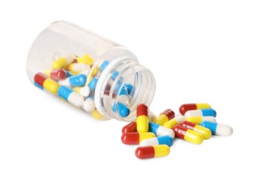 Scattered antibiotic pills and bottle isolated on white