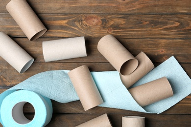 Photo of Flat lay composition with toilet paper and empty rolls on wooden background