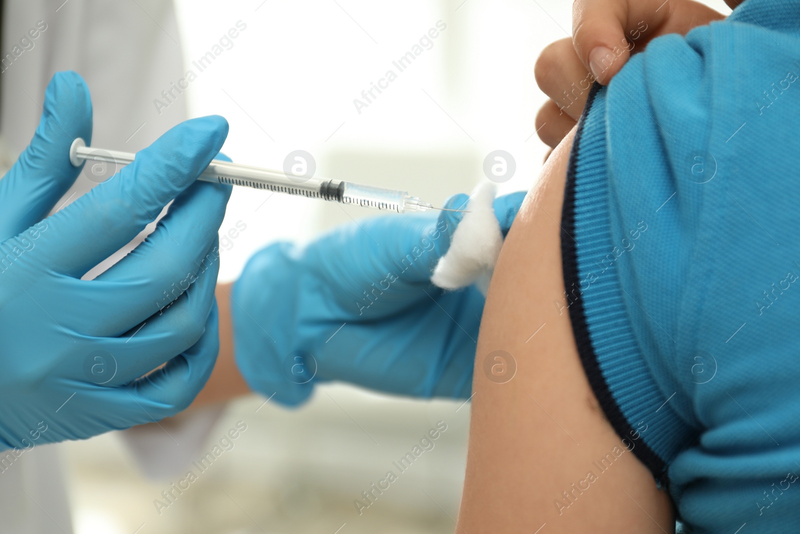 Photo of Doctor vaccinating little child in clinic, closeup