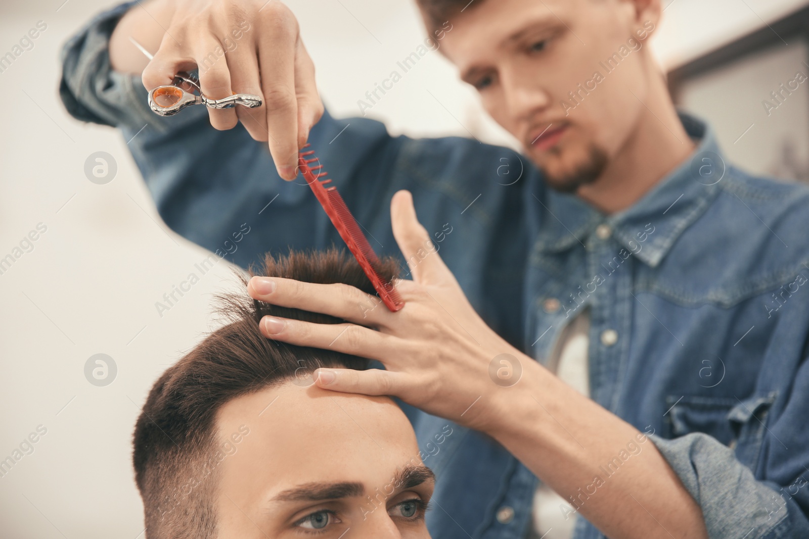 Photo of Professional barber working with client in hairdressing salon. Hipster fashion