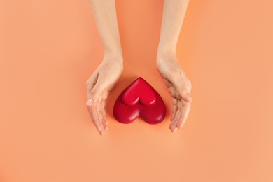 Woman with decorative hearts on color background, top view