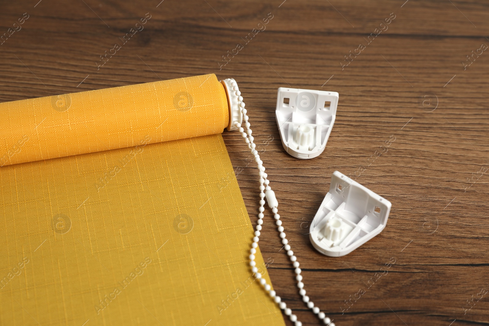 Photo of Stylish roller window blinds and details
on wooden table