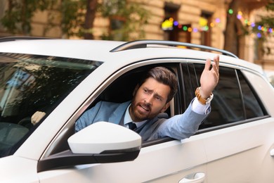 Photo of Stressed driver looking out of car in traffic jam