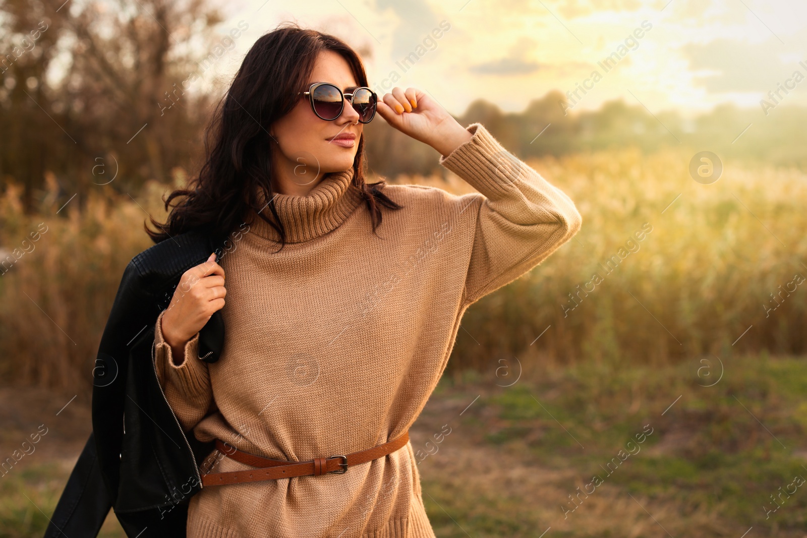 Photo of Beautiful young woman wearing stylish autumn clothes outdoors